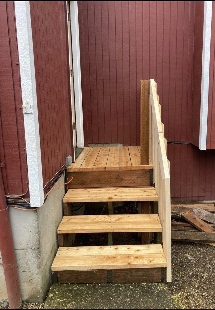 A wooden staircase is being built in front of a red building.