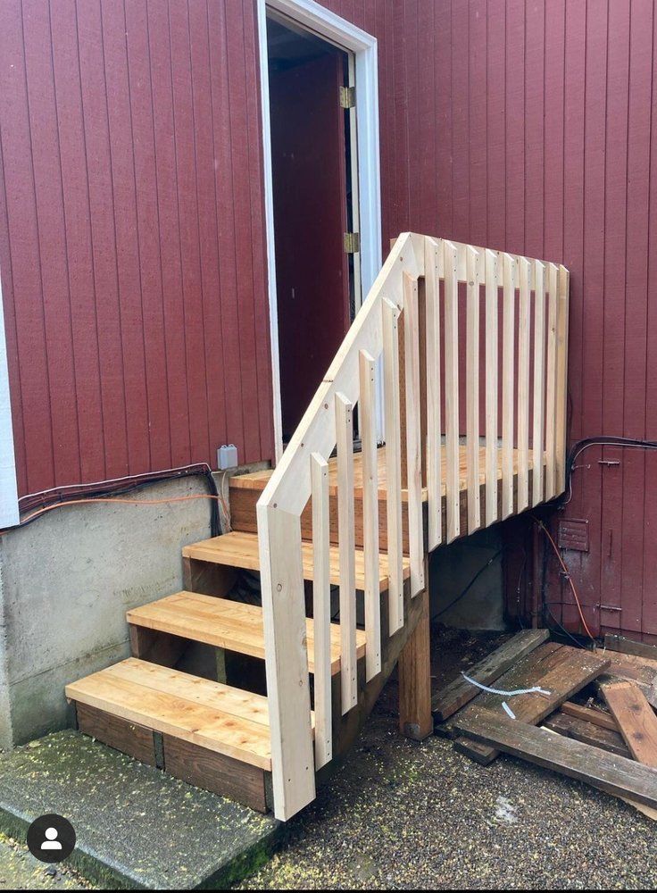 A wooden staircase leading up to a red house.