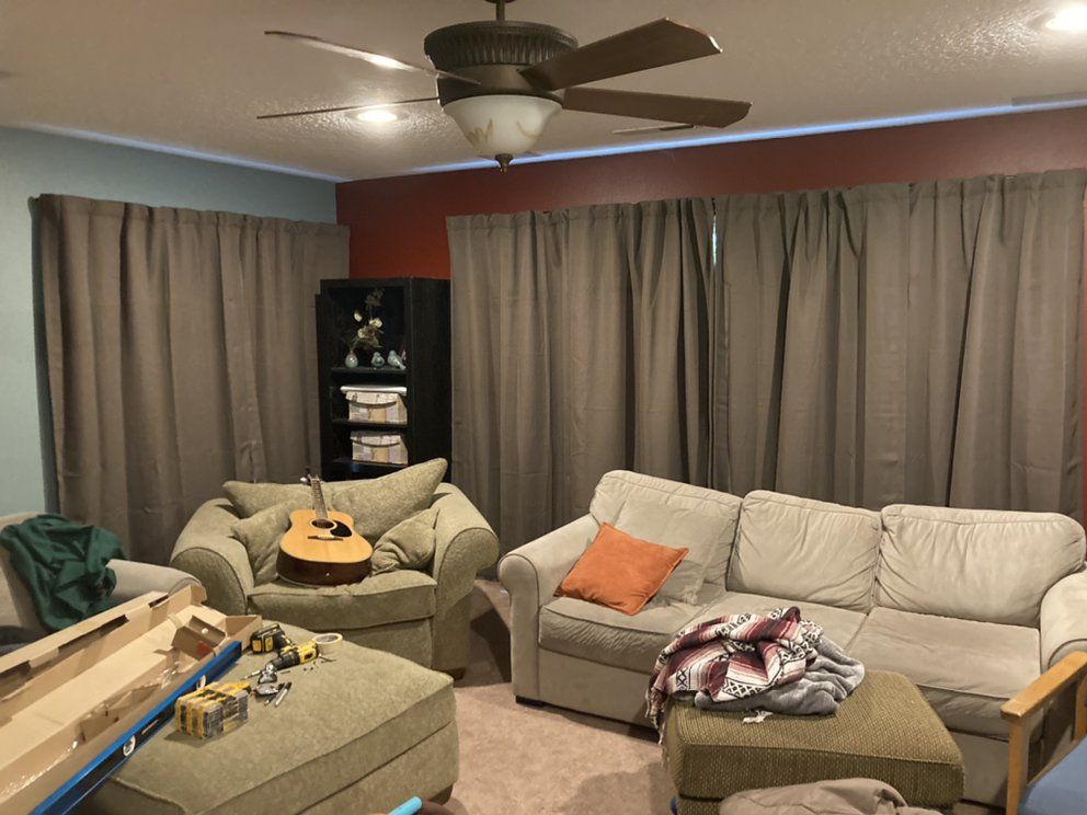 A living room with a couch a chair and a guitar
