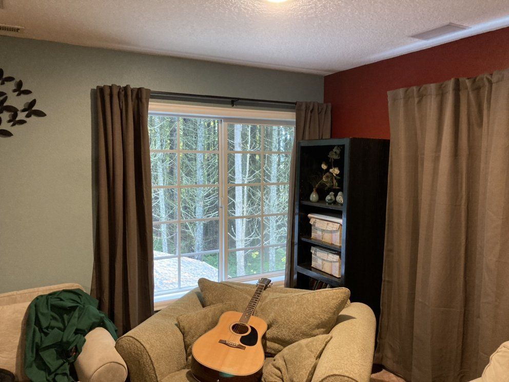 A guitar is sitting on a couch in a living room