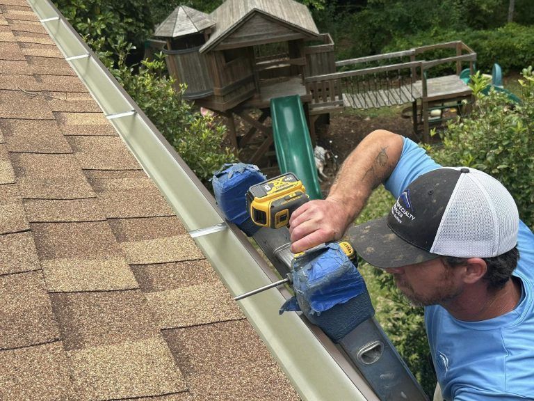 A man is working on a gutter on a roof.