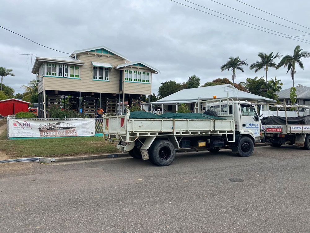 White Truck Parked in Front of a Raised House — House Lifting Services in Garbutt, QLD