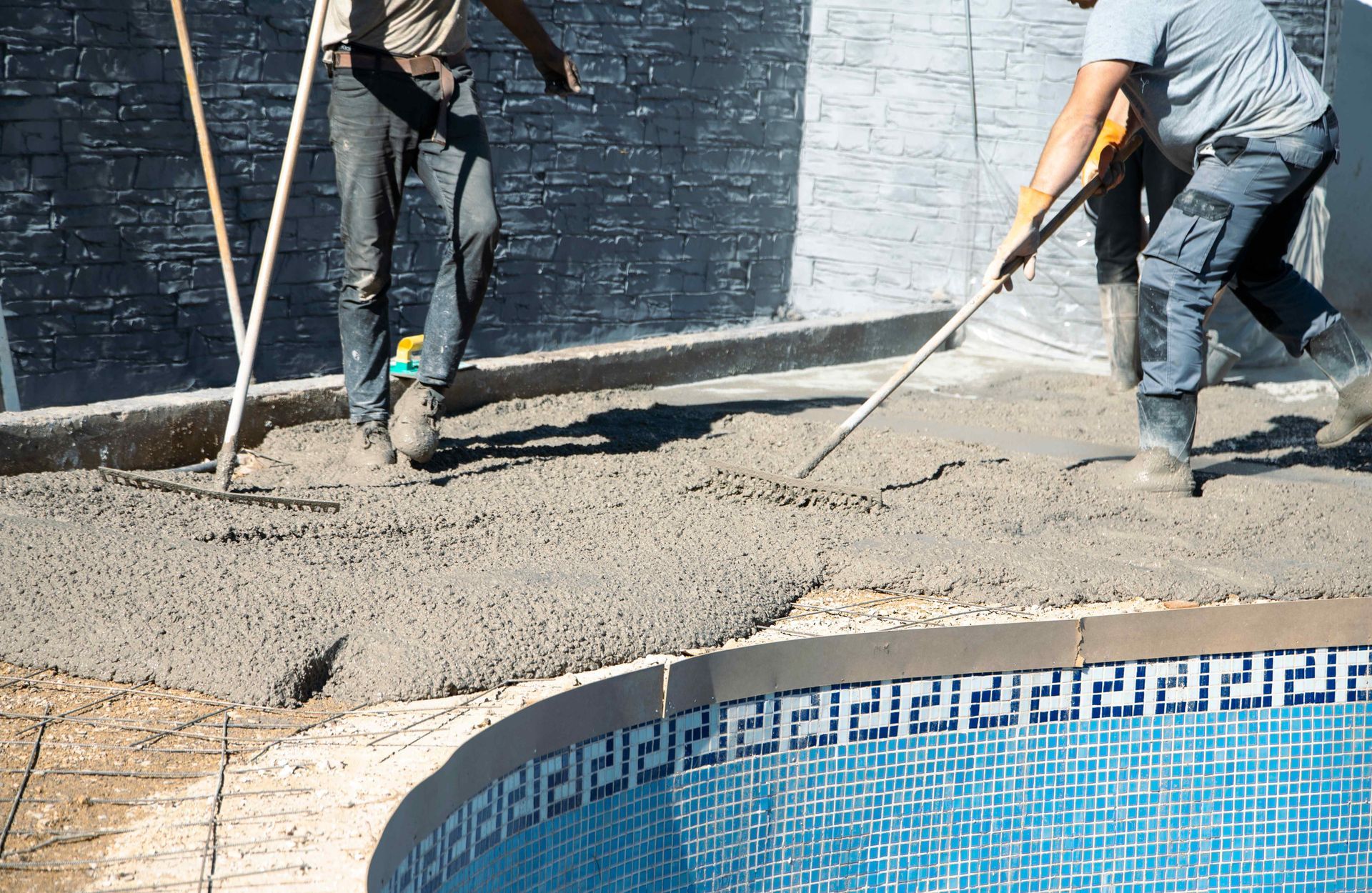 Pool contractors spreading concrete out for the hardscaping around the new pool