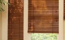 A pair of wooden blinds are hanging on a window in a room.