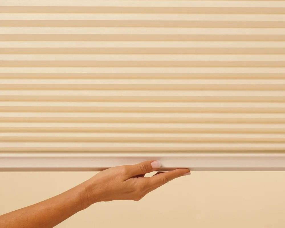 A person is holding a honeycomb blind in their hand.