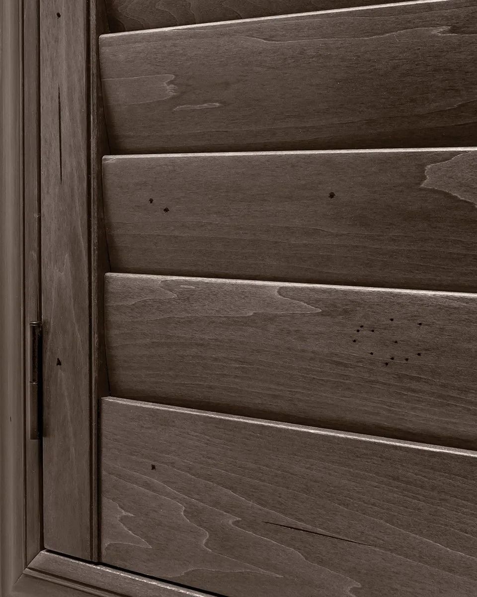 A close up of a wooden shutter on a window.