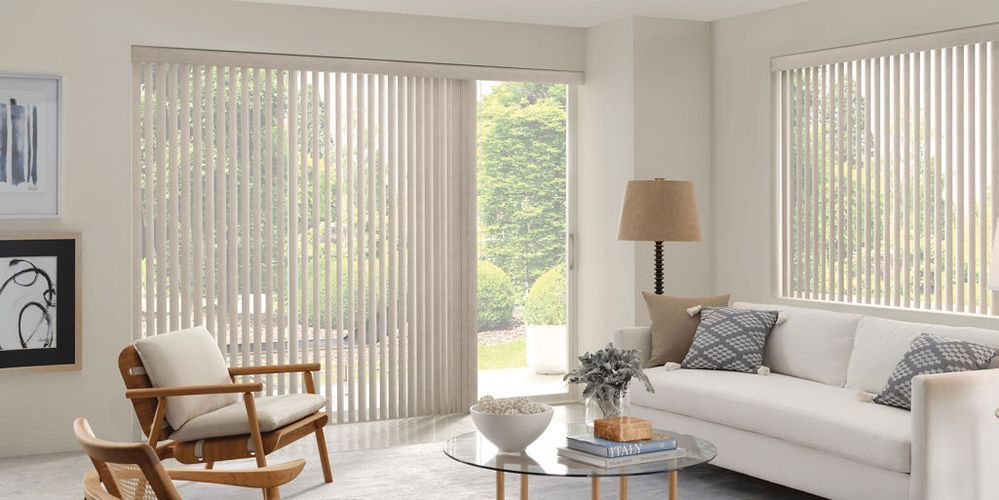 A living room with a couch , chair , table and blinds.