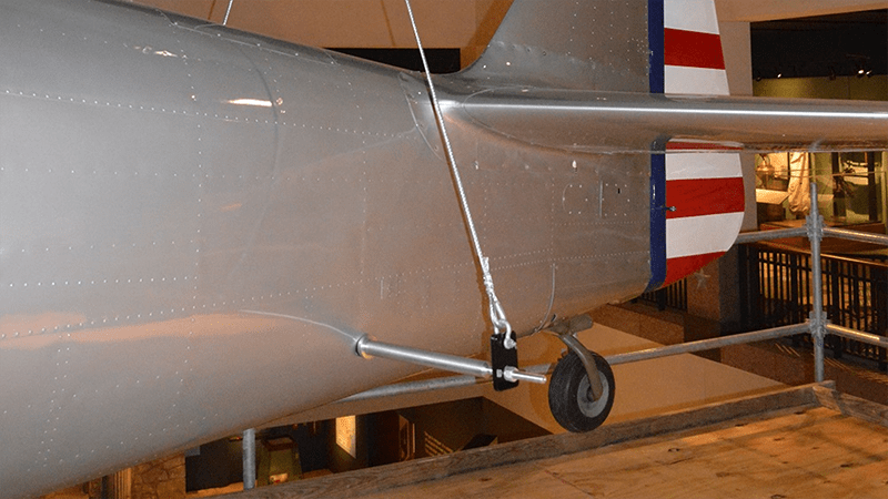 A silver airplane with a red white and blue stripe on the tail
