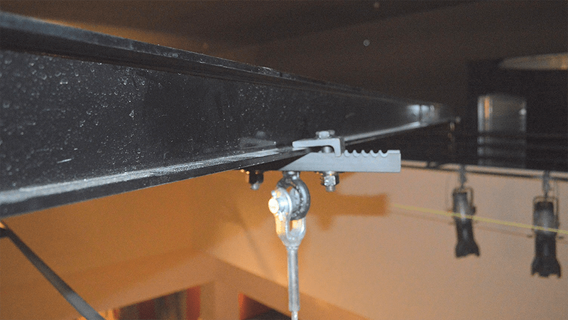 A close up of a metal beam with a hook attached to it.