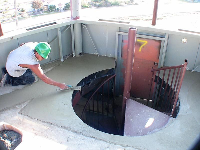 A man is painting a spiral staircase with a brush