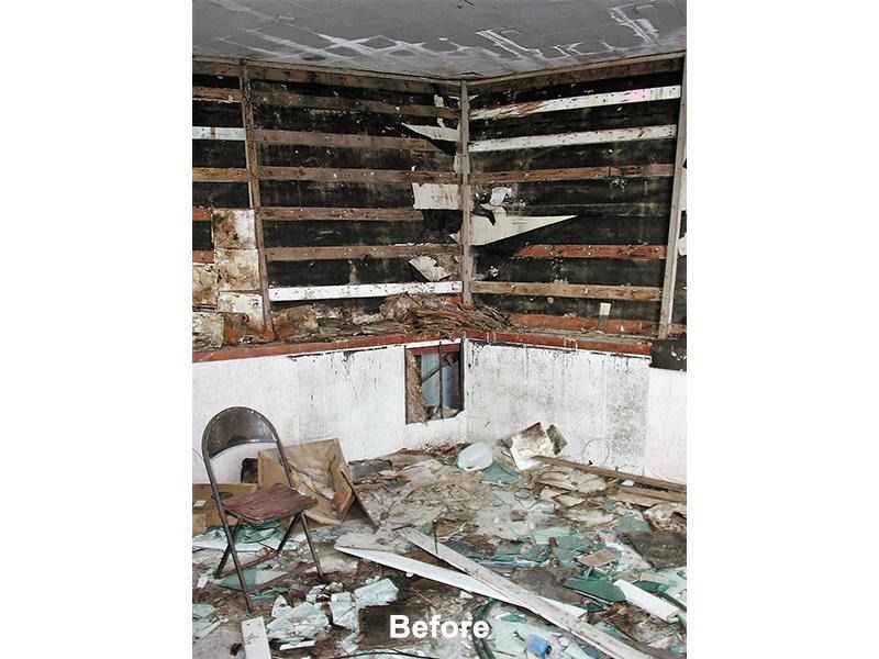 A before picture of a room with a chair and a broken window.