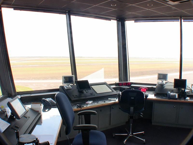 The inside of a control tower with a desk and chairs