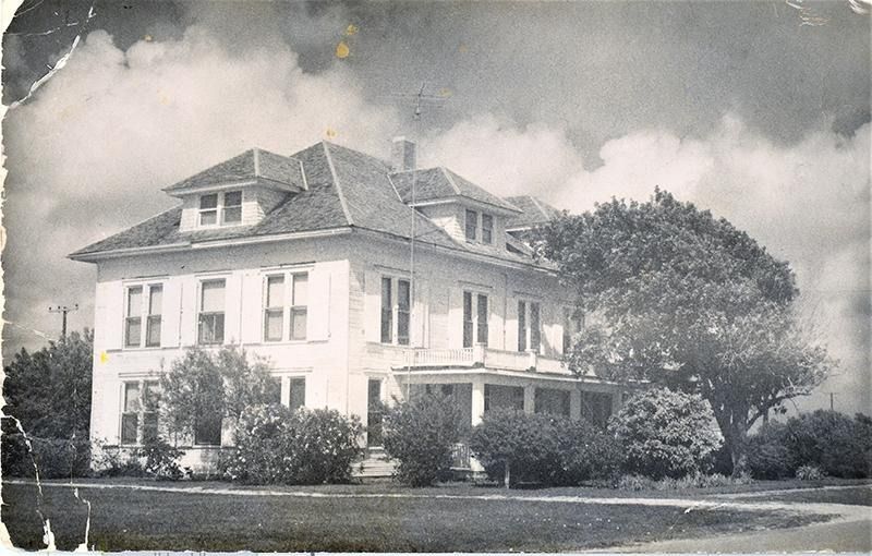 A black and white photo of a large white house