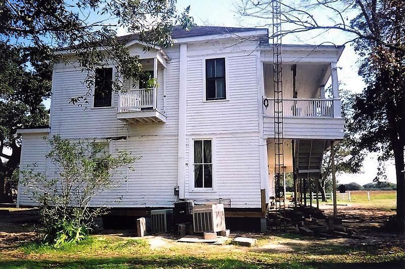 A white house with a ladder on the side of it