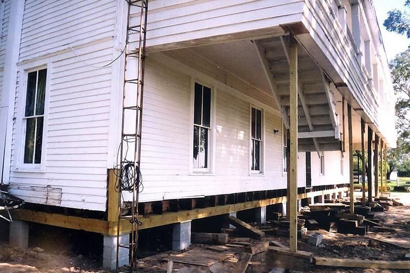 A white house with a ladder on the side of it