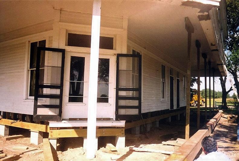 A white house with black doors is being moved