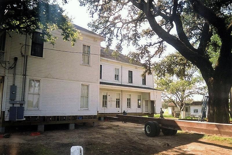 A large white house with a trailer in front of it