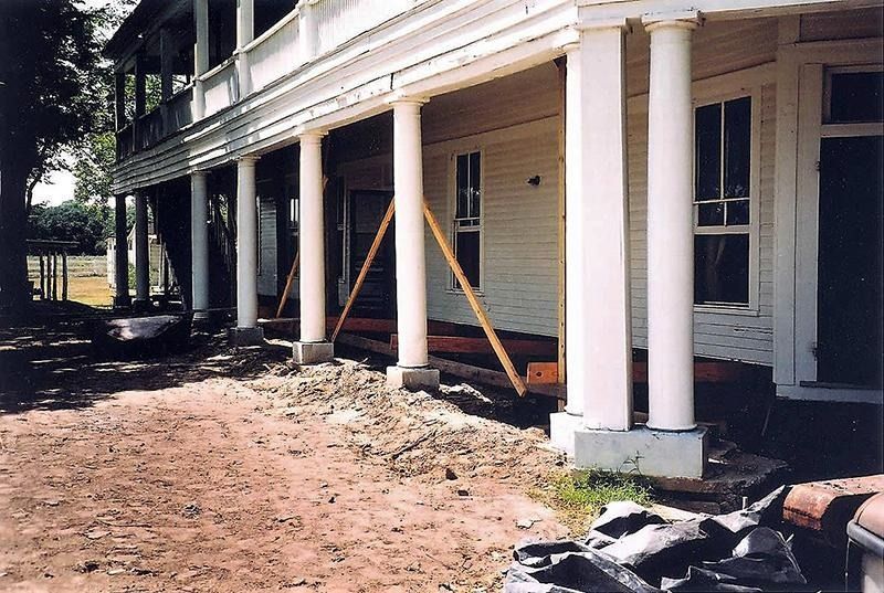 A large white house with a porch under construction