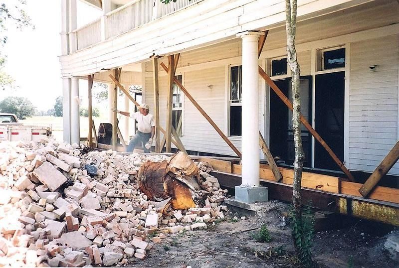 A man is standing in front of a pile of bricks