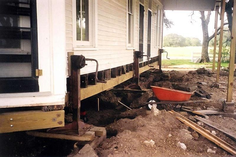 A house that is being moved with a wheelbarrow in front of it