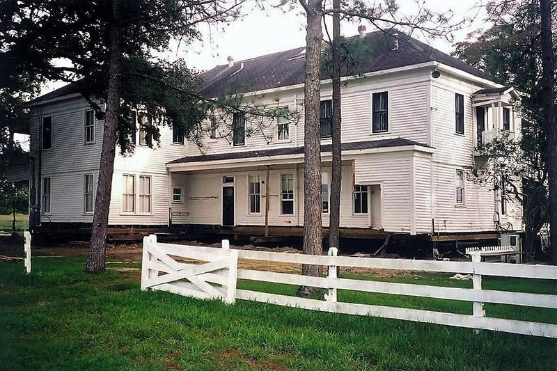 A large white house with a white fence in front of it
