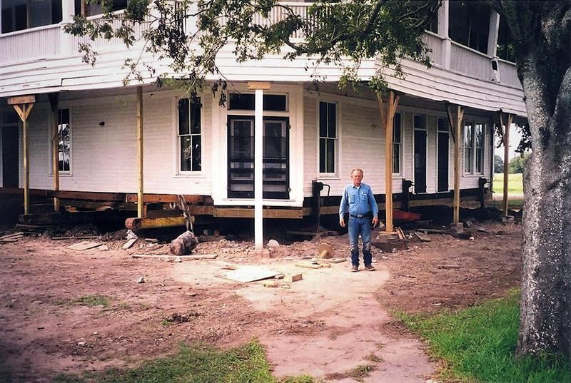 A man standing in front of a house that is being moved