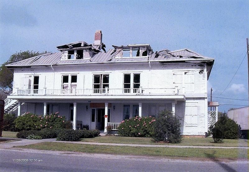 A white house with a roof that has fallen off