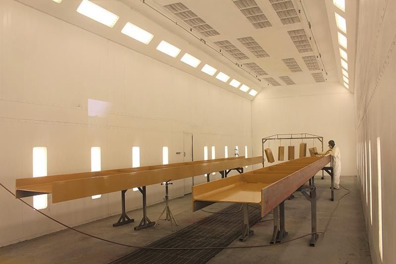 A long wooden table is sitting in a room with white walls.