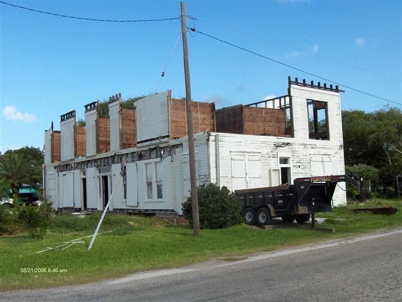 A truck is parked in front of a building that is being demolished