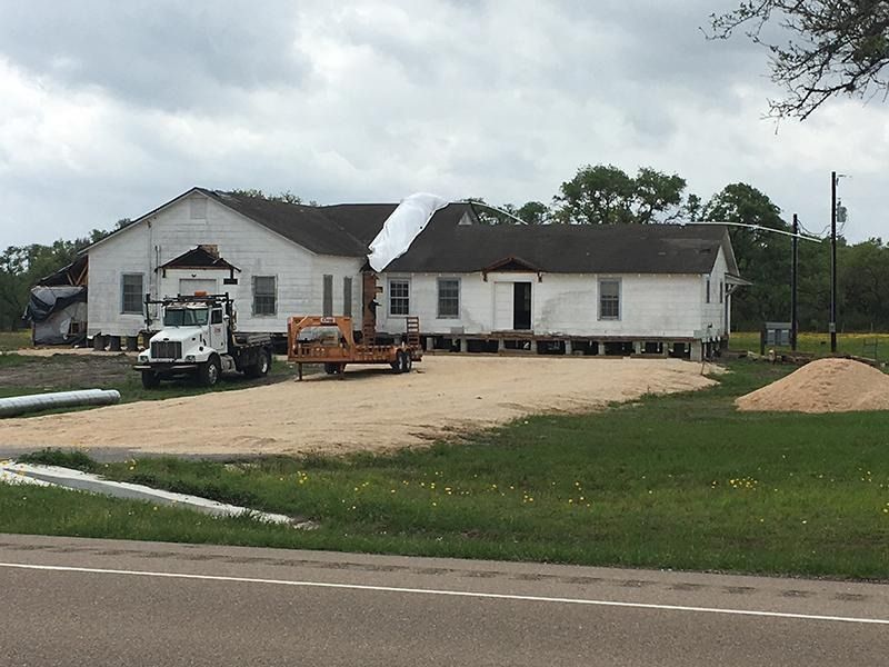 A truck is parked in front of a large white house
