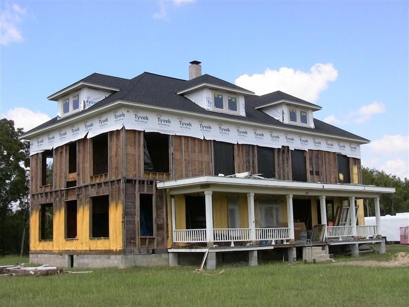 A large house with a porch is under construction