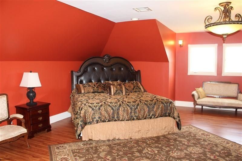 A bedroom with red walls and a large bed