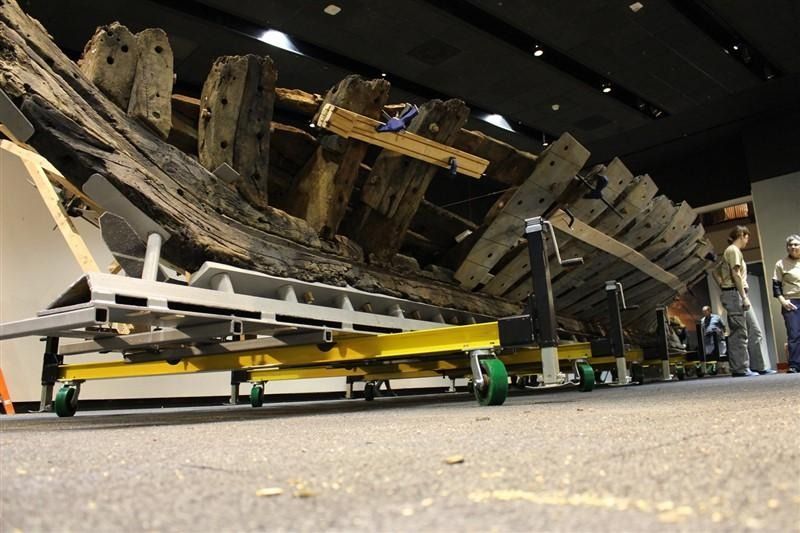 A large piece of wood is being moved on a cart