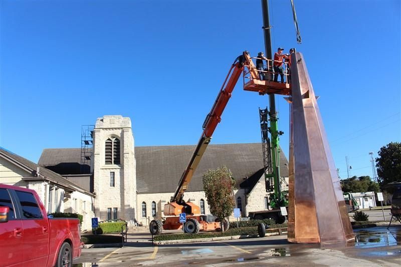 A red truck is parked in front of a church.