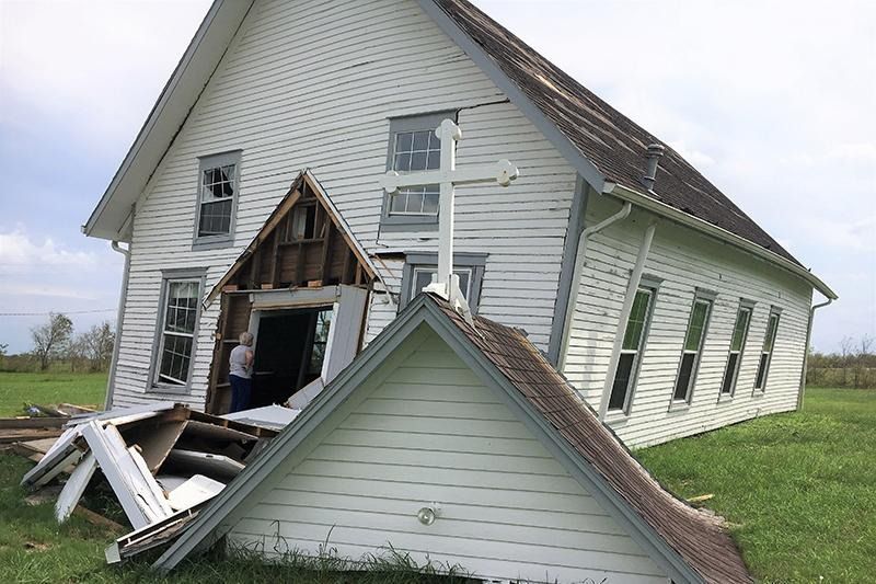 A white house with a cross on top of it