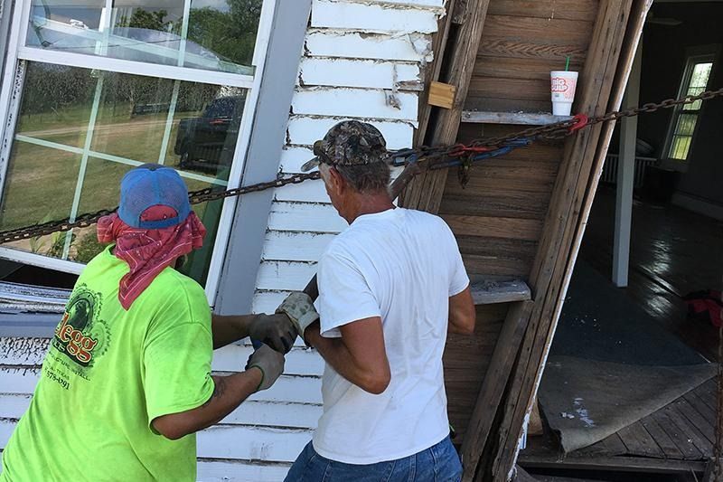 A man and a woman are working on a house.