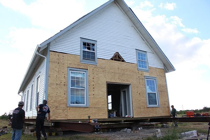 A white house is being moved to a new location