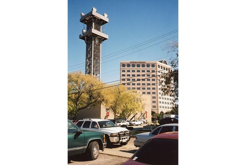 A parking lot with cars parked in front of a tall building