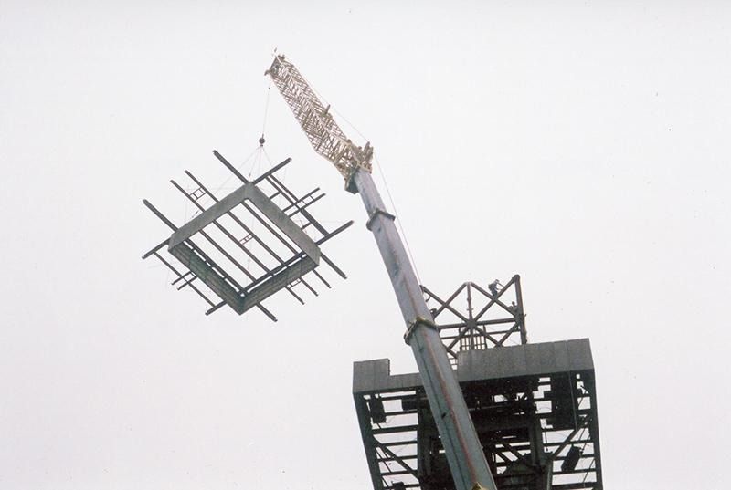 A crane is lifting a building in the air.