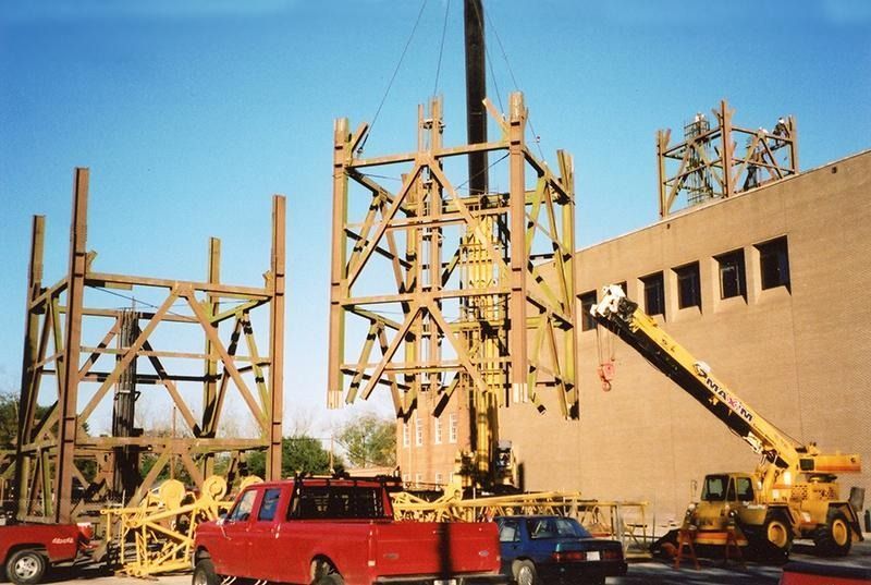 A red truck is parked in front of a building under construction