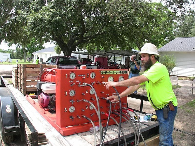 A man in a hard hat is working on a machine on a trailer