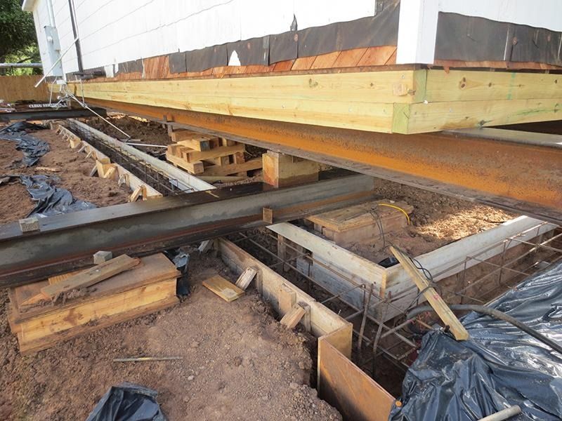 A wooden deck is being built under a house