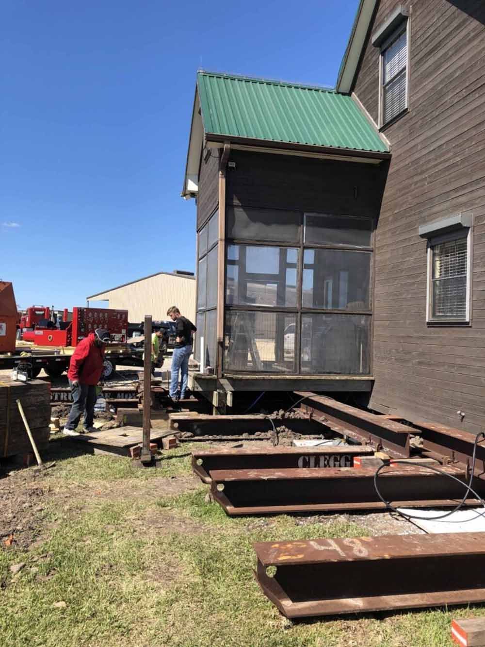A screened in porch is being moved into a house.