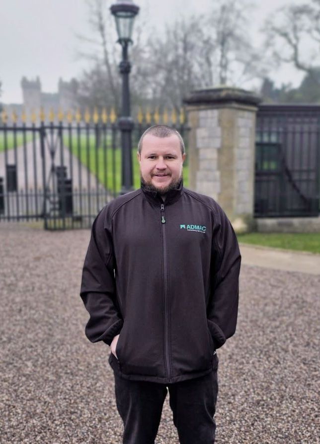 A man in a suit and tie is sitting on a couch using a tablet computer.