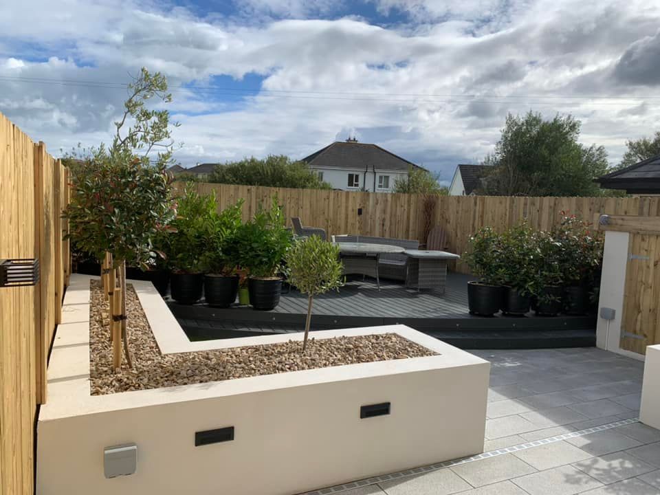 A patio with a table and chairs and a fence surrounding it.