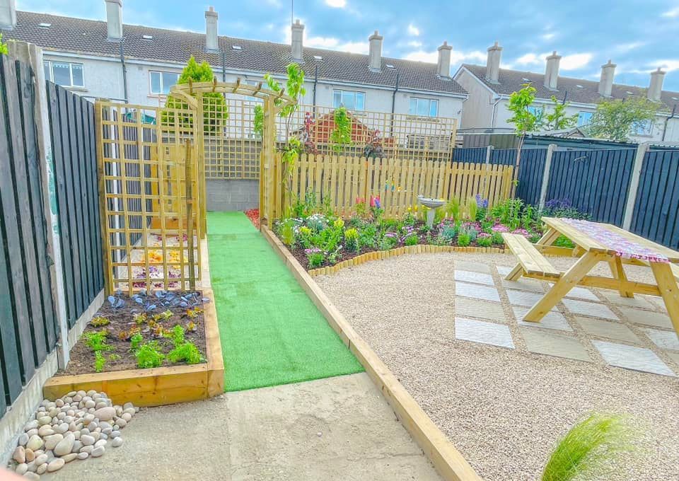 A garden with a picnic table and a fence