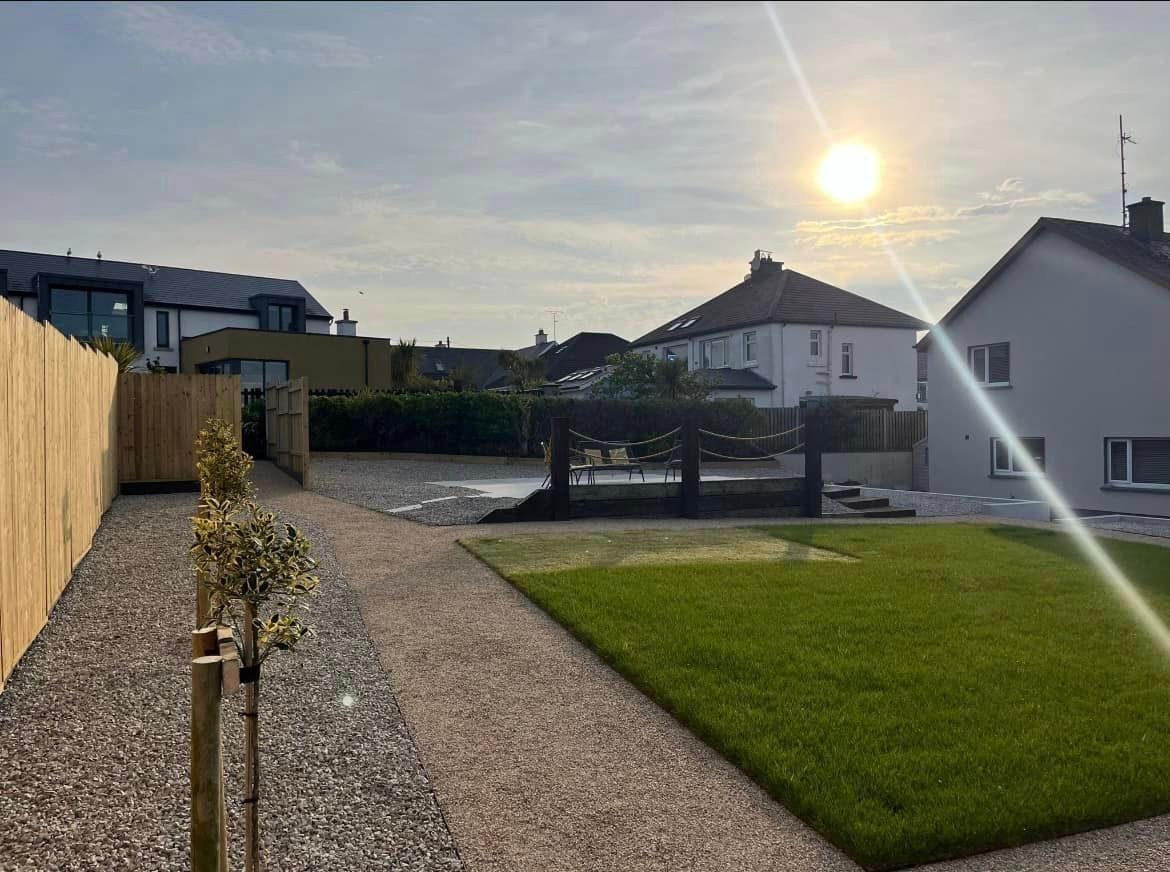 The sun is shining through the trees in the backyard of a house.
