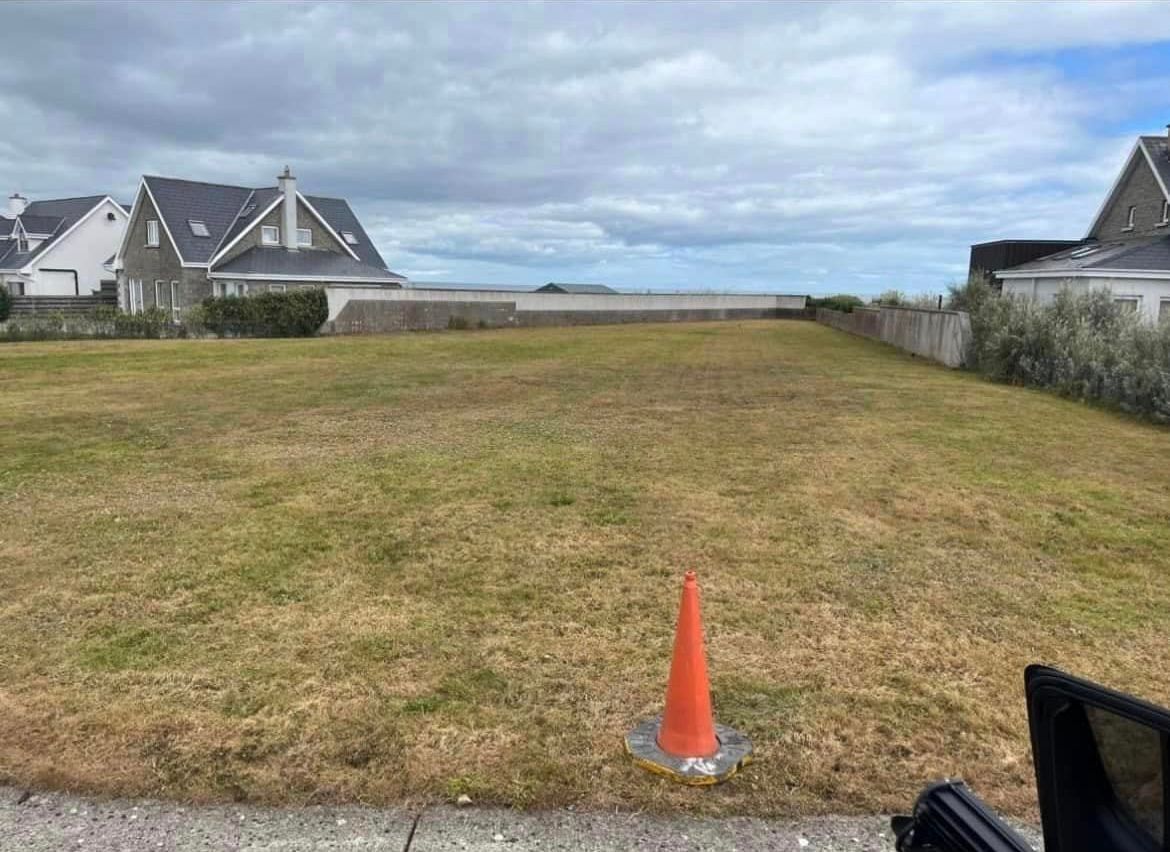 There is a traffic cone in the middle of a grassy field.