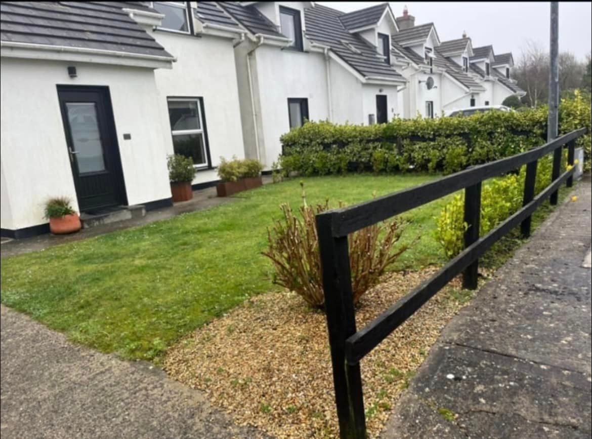 A white house with a black fence in front of it