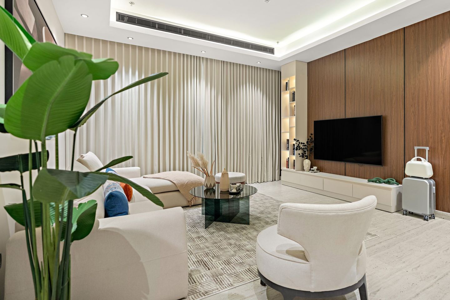 A living room with a couch , chairs , table and television.